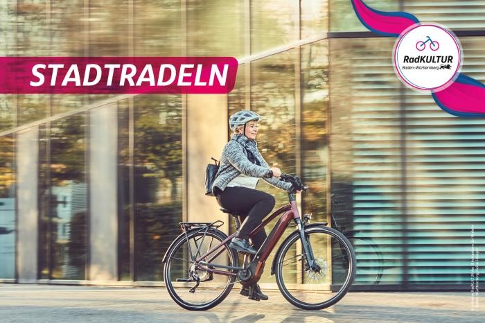 Stadtradeln Frau fährt mit Fahrrad vor Gebäude