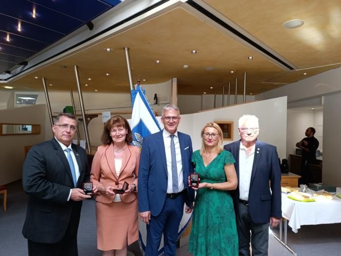 Das 77. Kirchweihtreffen der Budakesser Gemeinschaft Fünf Personen stehen nebeneinader für ein Foto. Drei der fünf Personen halten Medaillen in den Händen.