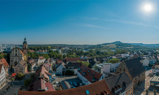 Blauer Musterwahlbrief, der in eine Wahlurne geworfen wird. 